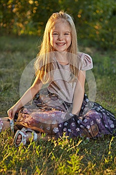 Little charming girl Sitting on the grass