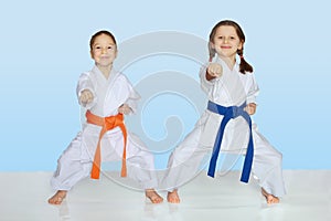 Little cheerful athletes in kimono beat punch hand