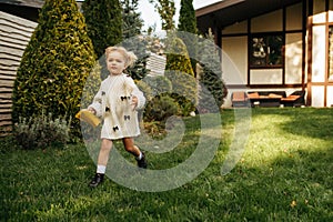 Little cheerful kid running in the garden