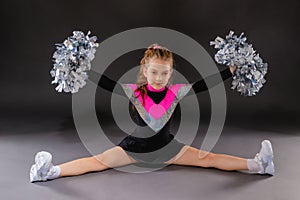 A little cheerleader girl does the splits