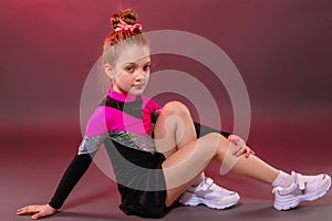 A little cheerleader girl posing for a photo before training