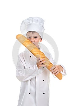 Little chef biting delicious fresh baguette.