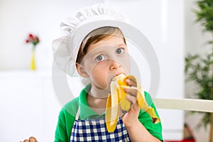 Little chef eating a banana