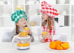 Little chef girls tasting the orange juice they made