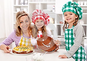 Little chef girls with their mother making a cake