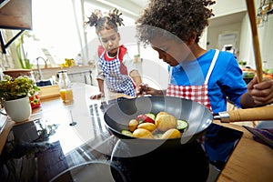 Little Chefs in Action: Boy and Girl Playfully Cooking Vegetables in the Kitchen