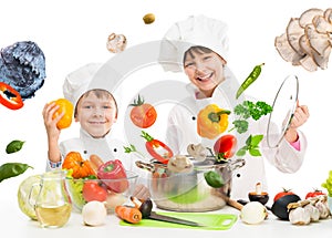 Little chefs by table with flying vegetables