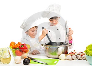 Little chefs by table with vegetables