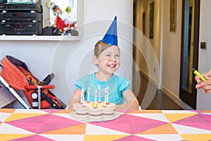 Little child with birthday cake smiling to mother