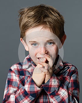 Little child biting fingers for boredom, stress or bad habit photo