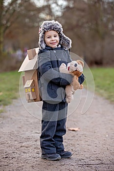 Little child, blond boy with pet dog, carying home on his back, kid, having paper house