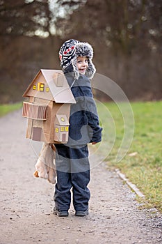 Little child, blond boy with pet dog, carying home on his back, kid, having paper house