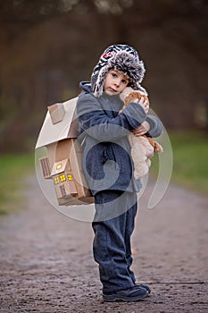 Little child, blond boy with pet dog, carying home on his back, kid, having paper house