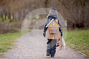 Little child, blond boy with pet dog, carying home on his back, kid, having paper house