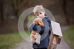 Little child, blond boy with pet dog, carying home on his back, kid, having paper house
