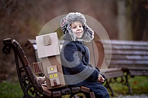 Little child, blond boy with pet dog, carying home on his back, kid, having paper house