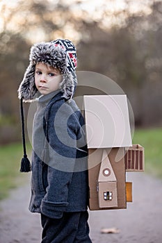 Little child, blond boy with pet dog, carying home on his back, kid, having paper house