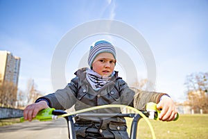 Little child boy on bicycle in park outdoor. A child is riding a children`s bike