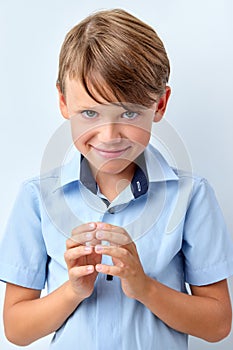 little child boy look in camera planning joke wearing shirt, isolated over gray background