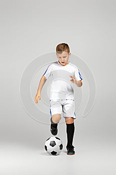 Little child boy in outfit play with soccer ball
