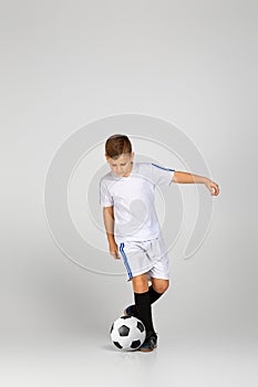 Little child boy in outfit play with soccer ball