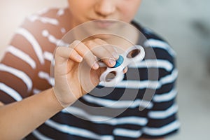 Little child boy playing with fidget spinner outdoors