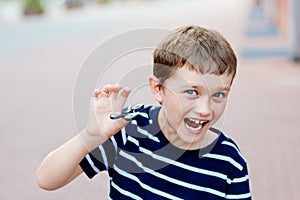 Little child boy playing with fidget spinner outdoors