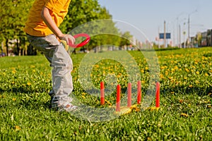 Little child boy playing. Ring throw summer game on a green lawn in the sun