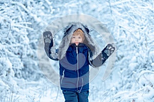 Little child boy walking in winter field. Boy dreams of winter time. Happy winter time. Active winter children concept.