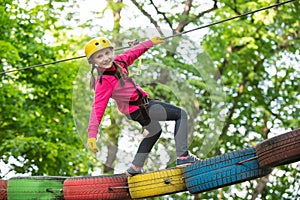 Little child climbing in adventure activity park with helmet and safety equipment. Helmet - safety equipment for Child