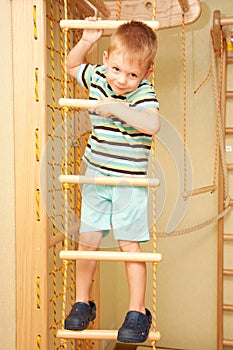 Little child climbing on rope ladder.
