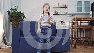 Little child daughter a sing dancing at home. Stay home active leisure happy childhood concept. Child daughter dancing