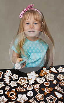 Little child decorating cookies with icing