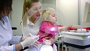 Little child in dentists surgery learning how to brush teeth