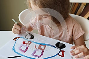 Little child draws with watercolor, concept of education in the kindergarten