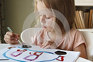 Little child draws with watercolor, concept of education in the kindergarten