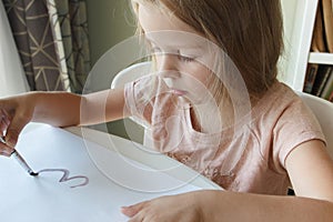 Little child draws with watercolor, concept of education in the kindergarten