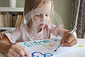 Little child draws with watercolor, concept of education in the kindergarten