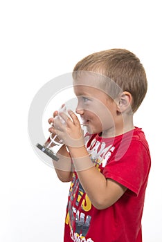 Little child drinking fresh and pure water from glass