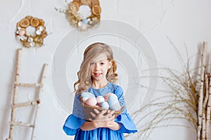 little child on Easter day. Girl holding basket with painted eggs