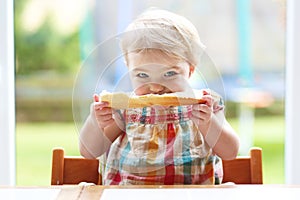 Little child eating bread with butter