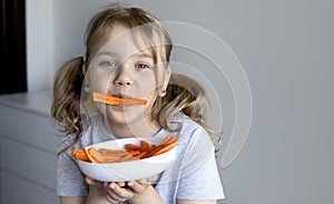Little child eating carrots empty space background. Healthy nutrition concept. Kid girl eats vegetables
