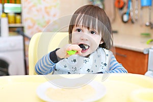 Little child eating porridge