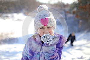 Little Child Eating Snow from Glove on Cold Winter Day