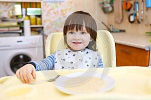 Little child eats wheat porridge