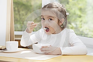 Little child eats yogurt