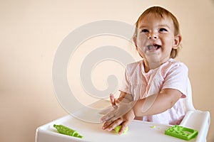 Little child engaged in playdough modeling at table, copy space. lifestyle