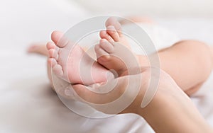 Little baby feet in mother hands closeup