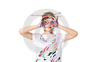 little child girl in colorful paint with paintbrush in hair