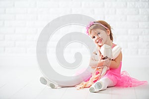 Little child girl dreams of becoming ballerina with ballet shoe